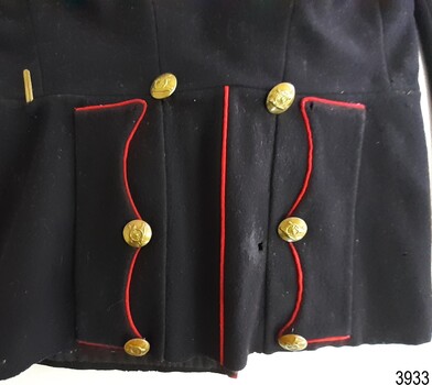 Back flat has red piping on edges, six brass buttons and a brass hook