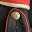 Brass epaulette button has same image as buttons on front and back of tunic