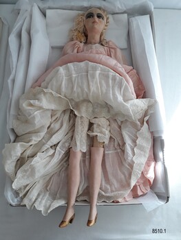 Front view of the Boudoir Doll's porcelain legs, gold painted shoes and white embroidered bloomers.