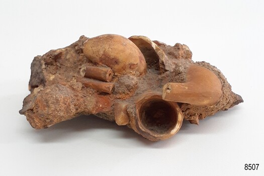 Conglomerated sand and soil, containing portions of clay tobacco pipes