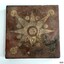 Square brown ceramic floor tile wit cream coloured 8-point star and circle pattern