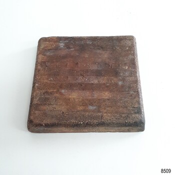 Underside is brown and has alternate parallel high and low ridges. It has an inscription moulded into it.