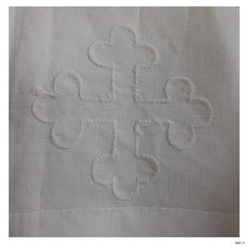 White embroidered cross outline on a white cloth