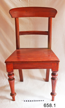 Front of stained wooden chair with curved backrest