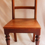 The wooden chair is facing the camera. It has turned legs.