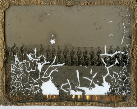 Gilt metal framed glass with photographic image of military figures in front of hills and buildings