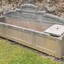 On the right end of the trough there is a small division that has a removable concrete cap that covers the opening. There is a depression in the centre of the cap that possibly once had a handle fitted there. This end of the trough has several chipped areas of damage. Inside the larger side of the trough there are colour changes in the concrete that are likely to have been caused by different levels and types of contents.