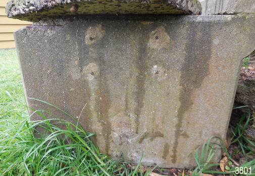 There are five round, lighter coloured areas around metal within the concrete of the trough.