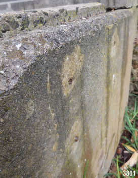 The embedded metal slightly juts out from the concrete wall.