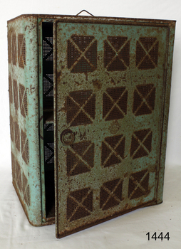 Rectangular cupboard, green painted metal, door on one side, handle at top, sides have airflow holes