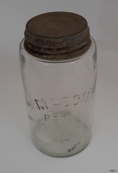 Clear glass jar has inscriptions embossed into glass