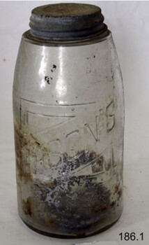 Jar has sediment inside. The text is moulded into the glass.