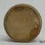 Round base of clay with imperfections has a chip on the edge