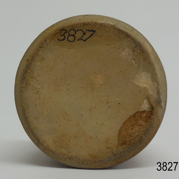 Round base of clay with imperfections has a chip on the edge