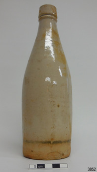 A beige stoneware bottle, possibly originally containing ginger beer. No stopper.