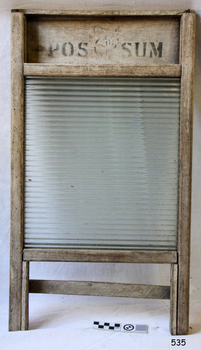 Rectangular ribbed glass pane within a wooden frame with two legs. Inscription across the top.