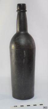 Black glass, cylindrical, bulbous neck. A narrow white line is down one side.