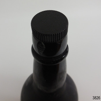 Stopper is black, has dimpled top and corrugated edges