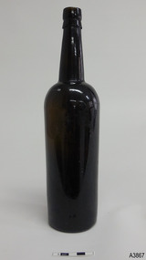 Tall slim bottle, dark glass, shiny surface