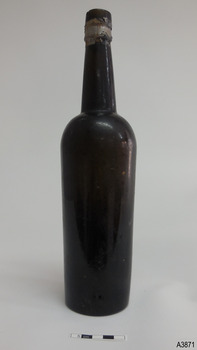 Tall bottle with long nick. Tape is around mouth. Bottle has shine.