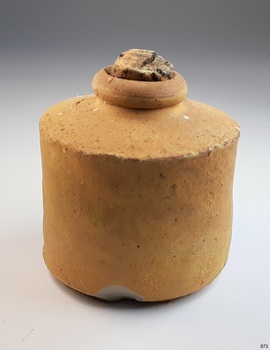 Brown clay bottle with cork; rolled lip, broad shoulders, straight sides. Chip in base.