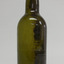Light shines green through glass. Sediment and pontil mark are visible through glass