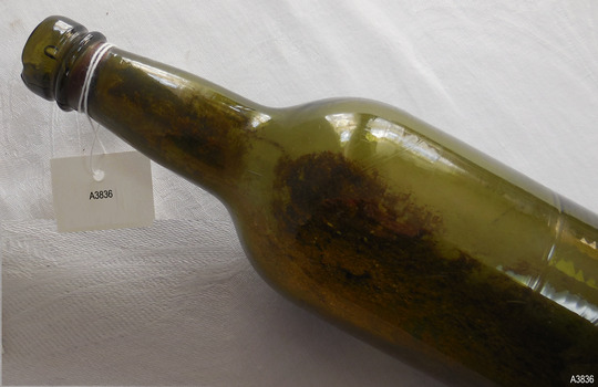 Bibble in lip, sediment, twist lines on shoulder, mould mark below shoulder, rippled glass in base.