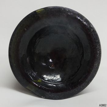 Round base has concave centre. Heel of base shows uneven colour in glass.