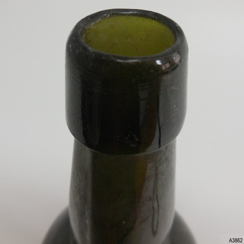 Edge of mouth is uneven, lip is deep and has thin horizontal lines in the glass
