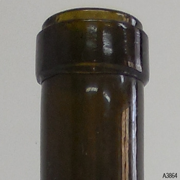 Lip has uneven lower edge and matt surface. Green of glass is opaque.
