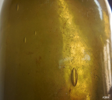 Opaque green glass has elongated bubbles in it