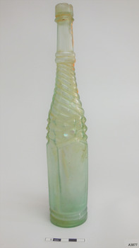 Clear glass with green tinge, whirley twisted pattern on shoulders, five plain panels on body