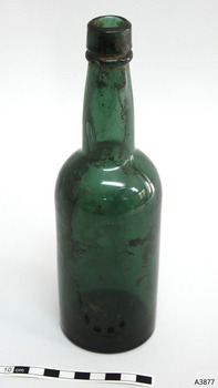 Blue green bottle, tall, sediment inside