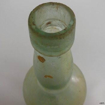 Mouth has uneven edge. Wide slightly tapered lip. Bulbous neck. Encrustations on surface.