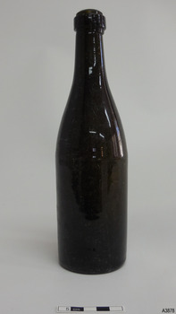 Dark brown glass bottle, tall and slim, , with a ring band on eck.
