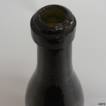 Mouth has uneven surface, ring band has straight sides, glass has visible concentric horizontal rings 