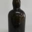 Brown bottle has bulbous neck and wide shoulders, tapering inwards towards base