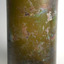 Label remnants on surface of glass with luminescence around the pieces.