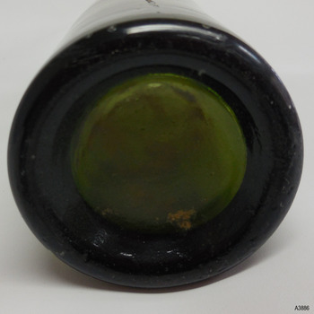 Bottle has thick heel and shallow base.