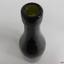 Bottle's mouth has bumps, collar has horizontal lines in glass, as does the neck. Neck's surface is scratched and lined.
