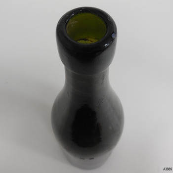 Bottle's mouth has bumps, collar has horizontal lines in glass, as does the neck. Neck's surface is scratched and lined.