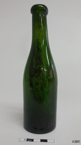 Green bottle is tall and slim with smooth lines and has a blob lip