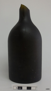 Bottle is black glass, has broken mouth, short neck, broad shoulder, body tapering slightly inwards