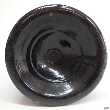 Base has thick heel and is pushed-up. There is a pontil ring in the centre. Glass has imperfections.