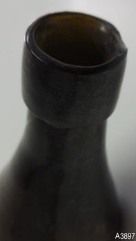 Edge of mouth has a chip. Collar is wide and has concentric rings in the glass. Neck is rippled.