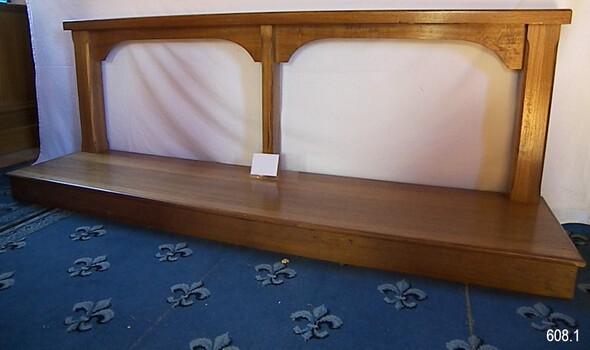 Wooden rail supported by three posts on a flat, rectangular timber board