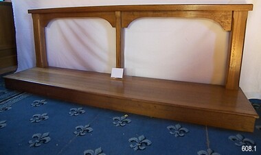 Wooden rail supported by three posts on a flat, rectangular timber board