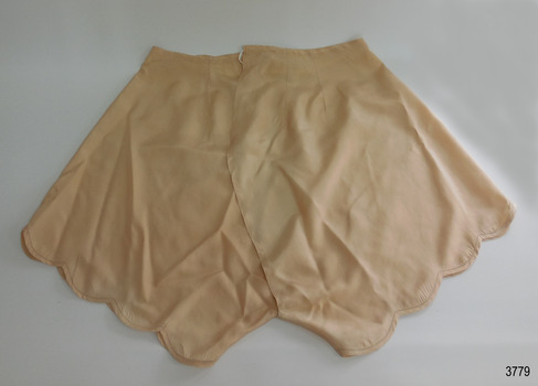 Beige silk drawers have scalloped legs and drawer string waist