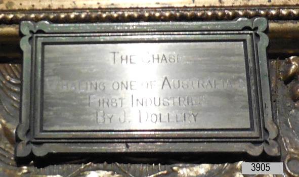 Plaque is embossed metal with Title and Artist's name.