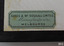 Green rectangular label has maker's details in three lines.